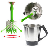 a hand holding a green brush and a stainless mug