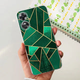 a person holding a green phone case with gold triangles