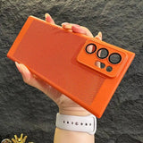 a hand holding an orange case with a pair of glasses