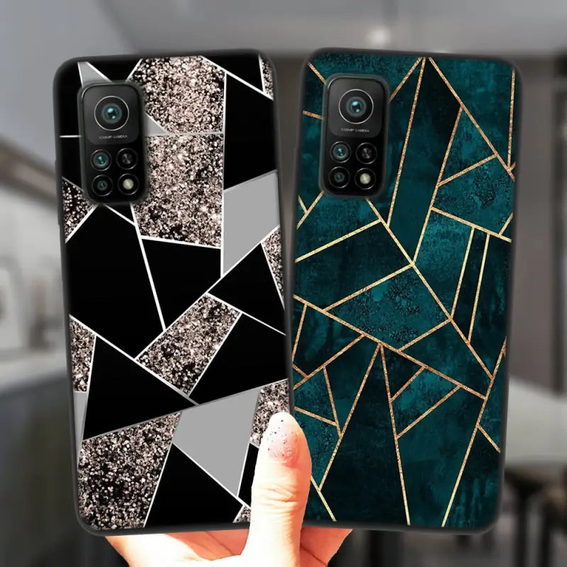 a hand holding a phone case with a black and gold geometric design