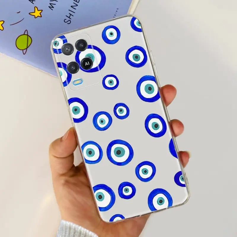 a hand holding a phone case with blue eyes