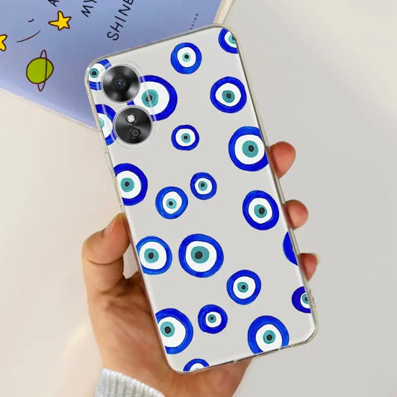 a hand holding a phone case with blue eyes