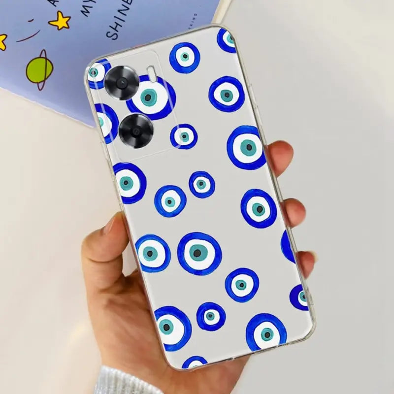 a hand holding a phone case with blue eyes