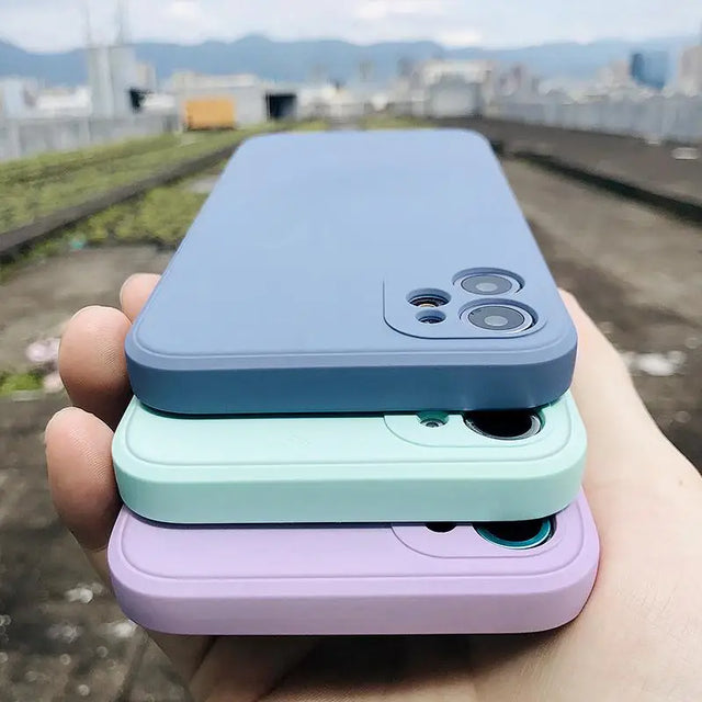 a hand holding a phone with a purple and blue case