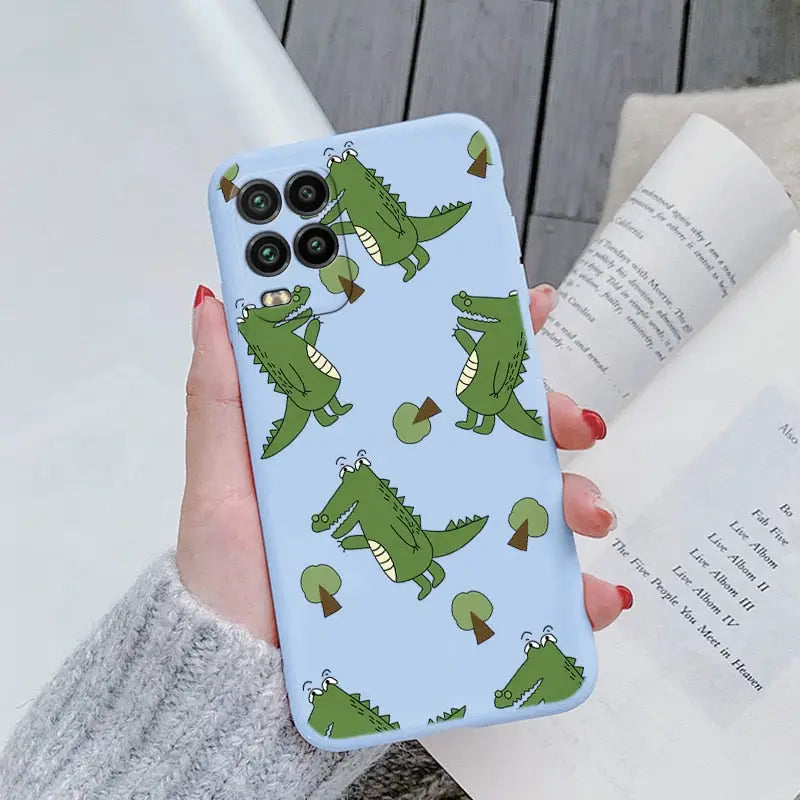 a woman holding a phone case with a pattern of crocodiles