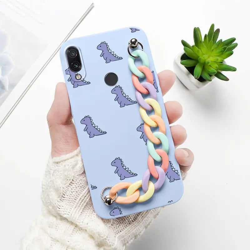 a hand holding a phone case with a colorful chain
