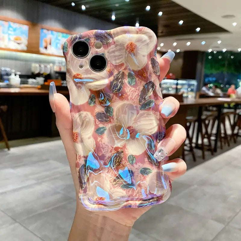 a hand holding a phone case with a colorful marble pattern