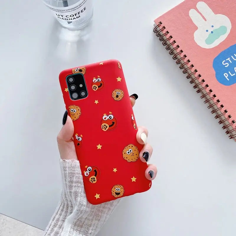 someone holding a red phone case with a cookie pattern on it