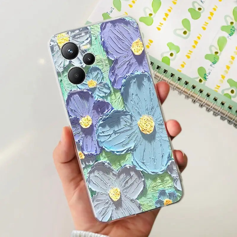 a hand holding a phone case with a floral pattern