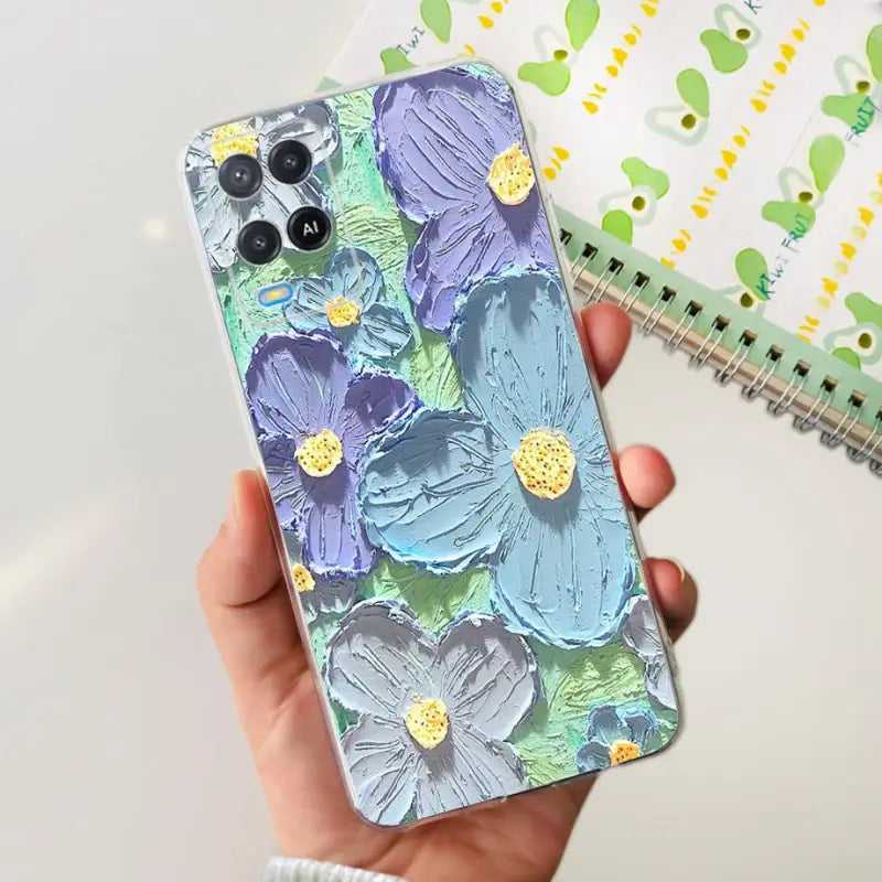 a hand holding a phone case with a floral pattern