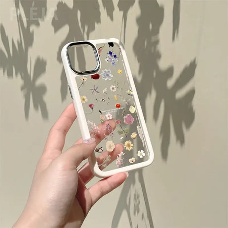 a hand holding a phone case with flowers on it