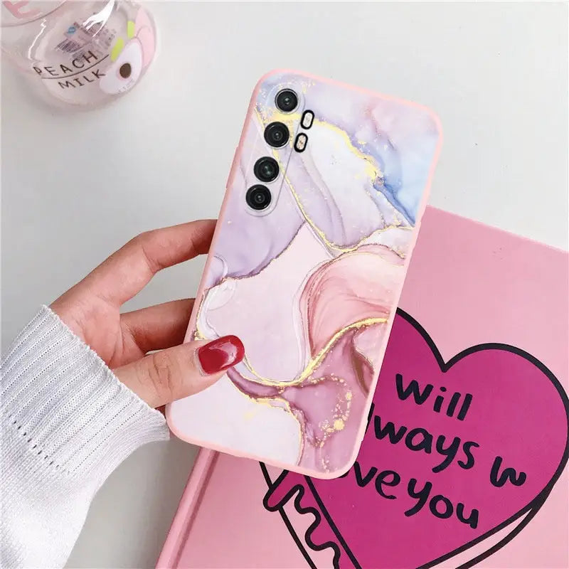 a hand holding a phone case with a heart on it