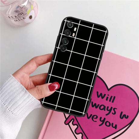 a woman holding a phone case with a heart on it