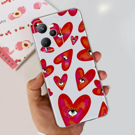 a hand holding a phone case with hearts on it