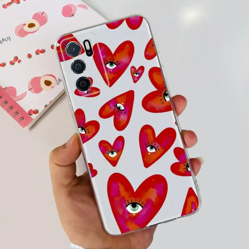 a hand holding a phone case with hearts on it