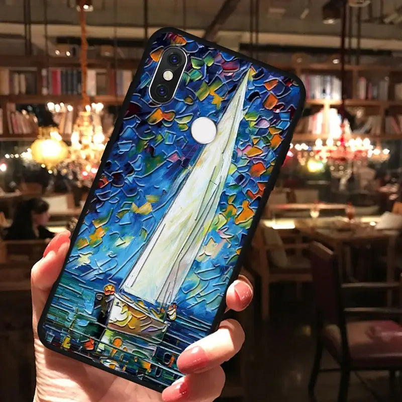 a hand holding a phone case with a painting of a sail