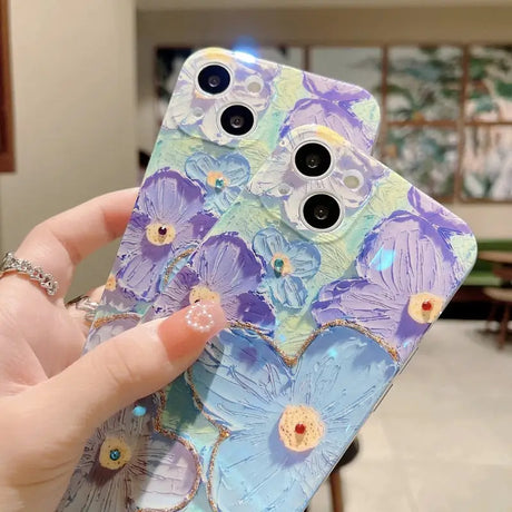 a hand holding a phone case with flowers on it