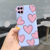 a hand holding a phone case with pink hearts on it