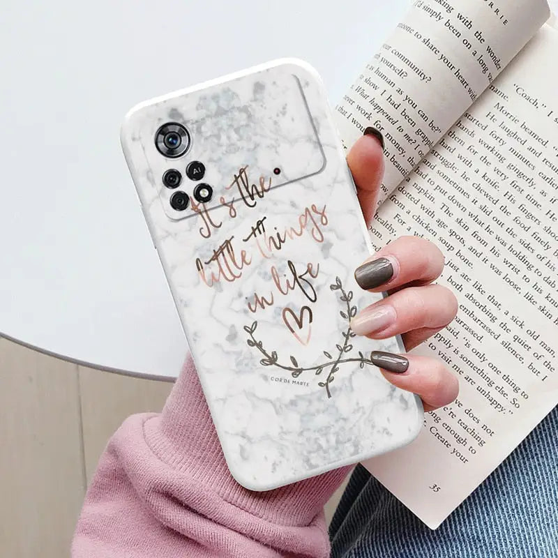 a woman holding a white marble phone case with the words i am to love