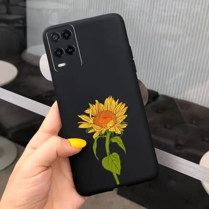 a hand holding a phone case with a sunflower on it
