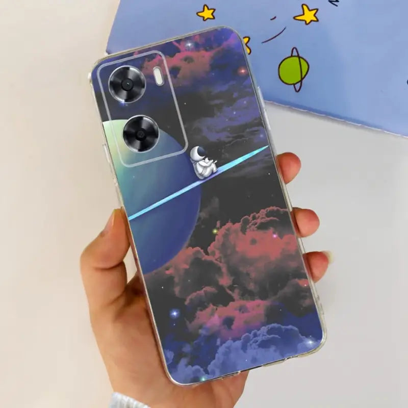 a hand holding a phone case with a space theme