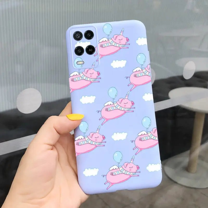 a hand holding a phone case with a pattern of whales and clouds