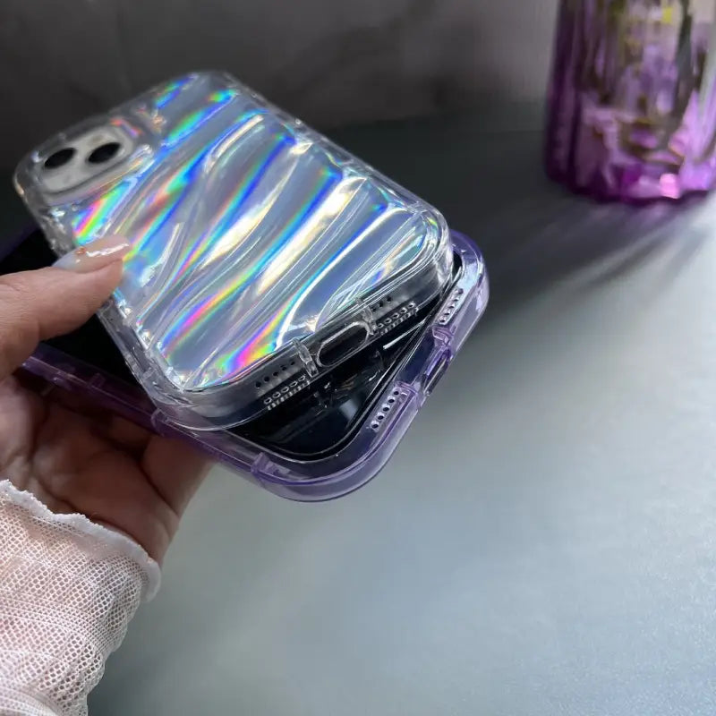 someone holding a phone in a clear case with a purple handle