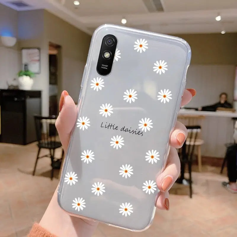 someone holding a phone with a little daisy design on it