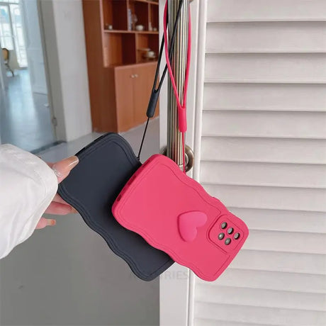 a hand holding a pink and black cell case