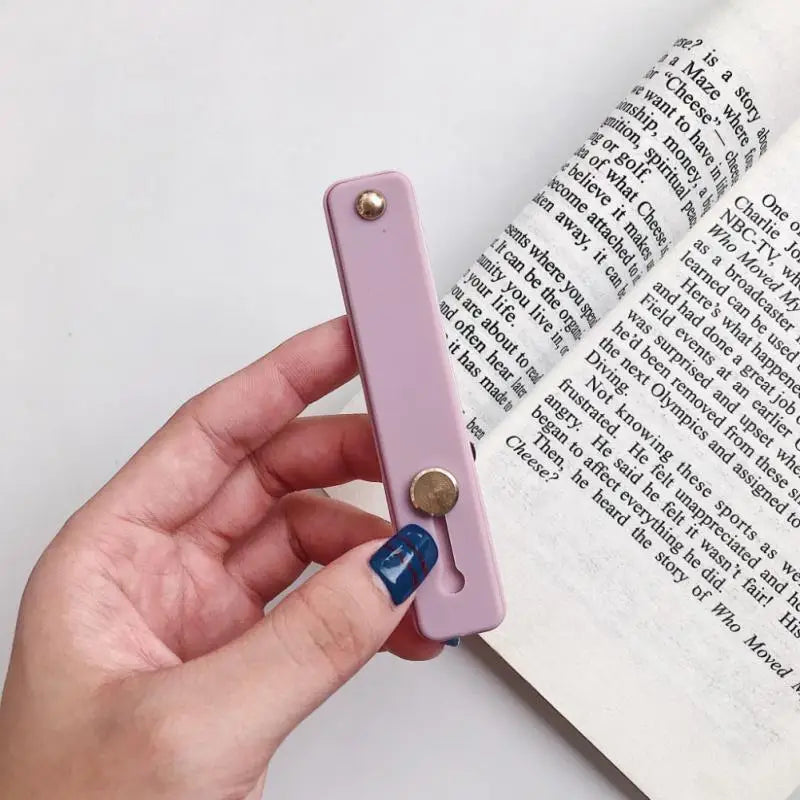 a hand holding a book with a purple cover