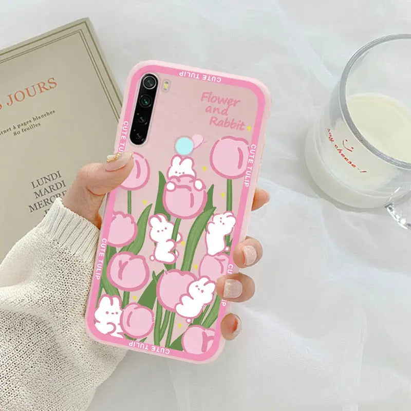 someone holding a pink phone case with a pink flower design