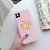 a hand holding a pink phone case with a crown on it