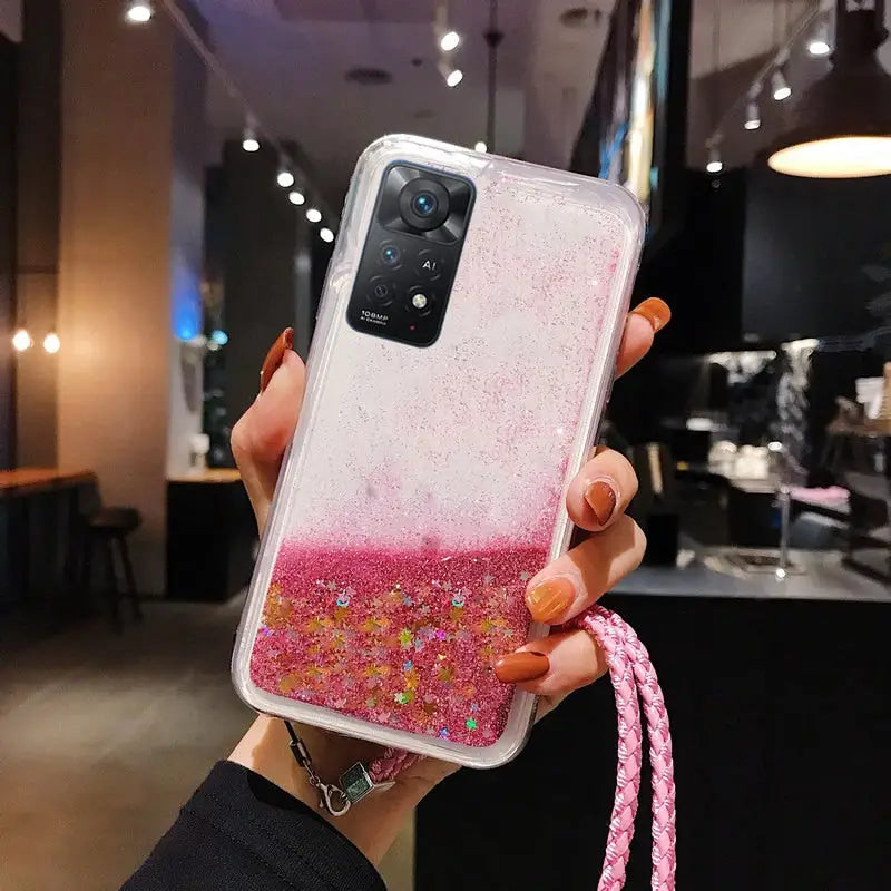 a woman holding a pink and gold glitter phone case