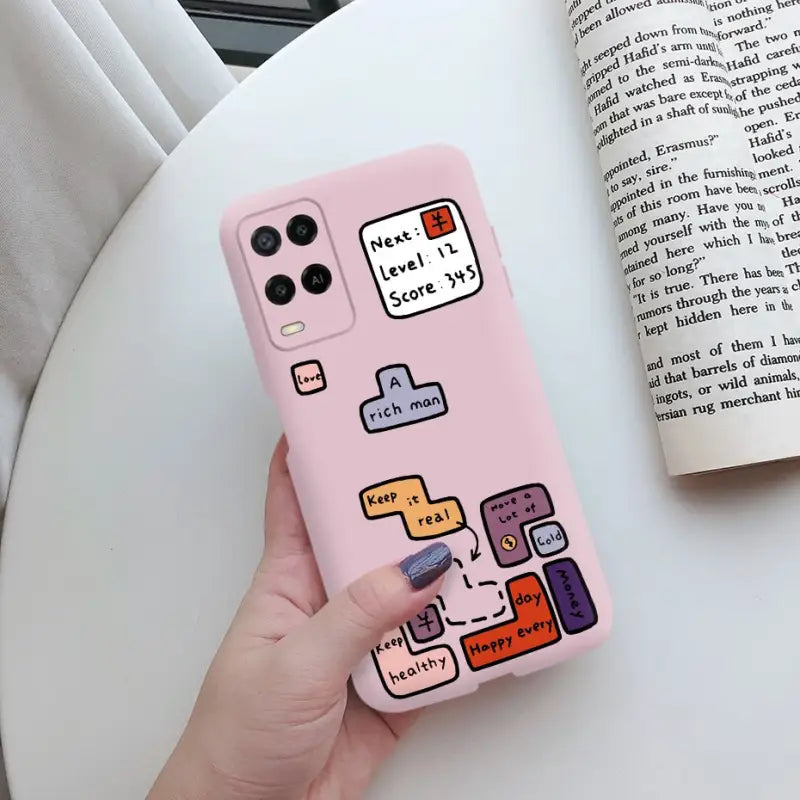 a hand holding a pink phone case with a cartoon design