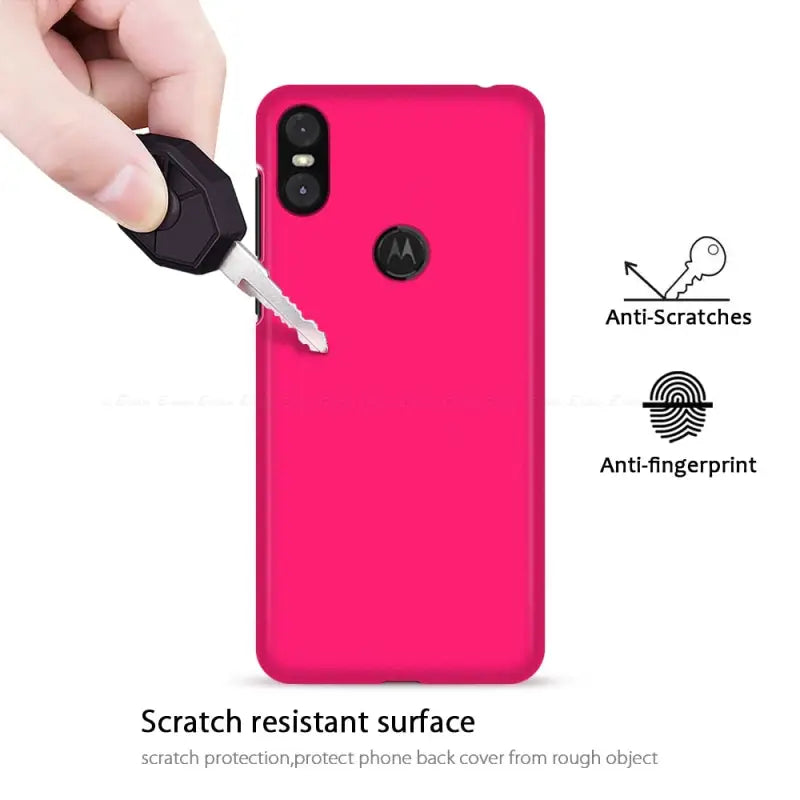 a hand holding a pink phone case with a key