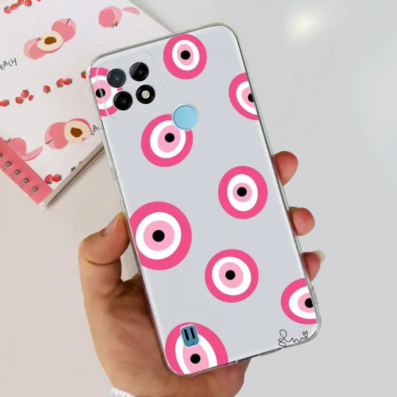 a person holding a phone case with pink and white circles on it