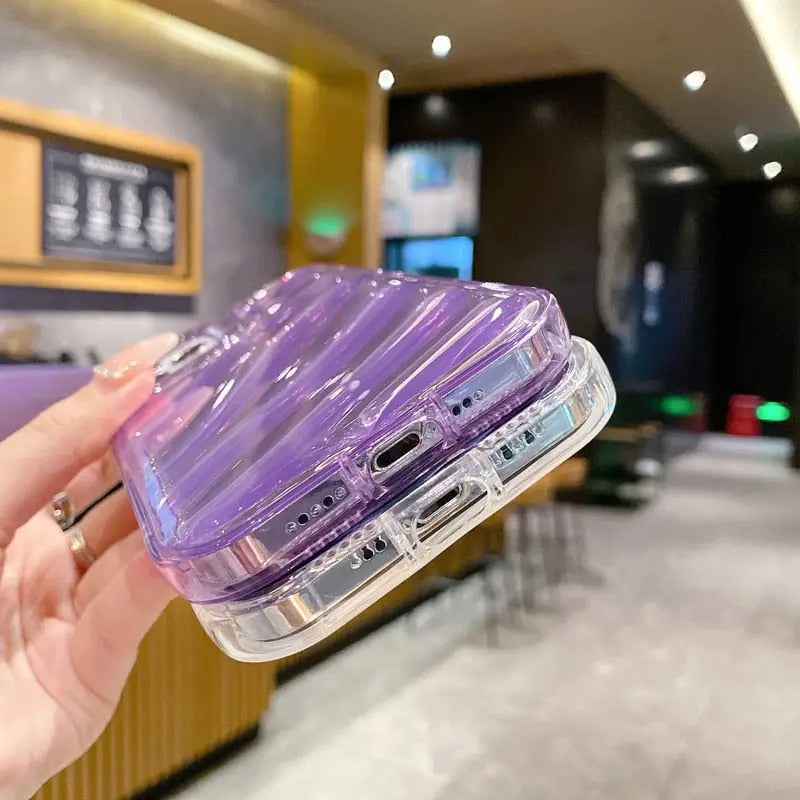 a hand holding a purple plastic case