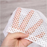 a hand holding a white lace with holes