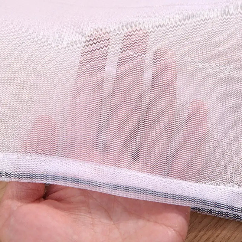 a hand holding a piece of white mesh