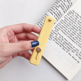 a hand holding a bookmark with a bookmark in the middle