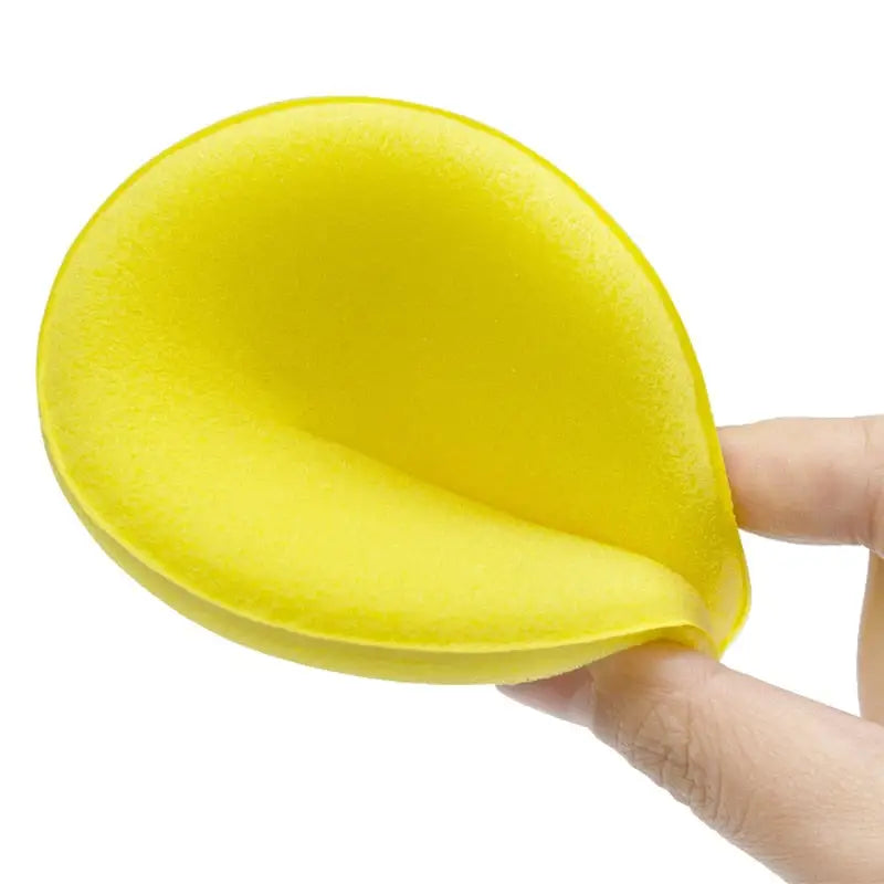 a hand holding a yellow sponge