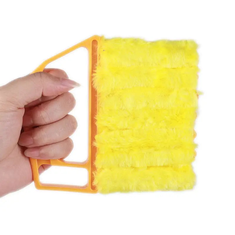 someone holding a yellow sponge with a handle in their hand