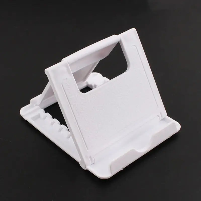 a white plastic phone stand on a black background