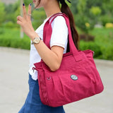 a woman in a white shirt and blue jeans is walking with a red bag