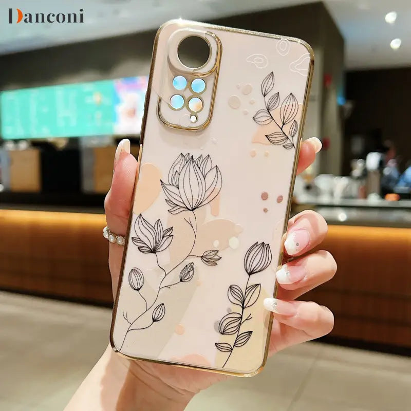 a woman holding a phone case with a flower pattern