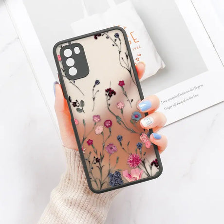 a woman holding a phone case with flowers on it