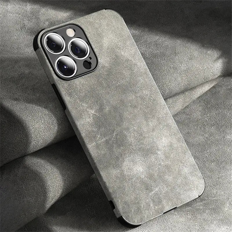 the back of a gray iphone case with a black phone in the background