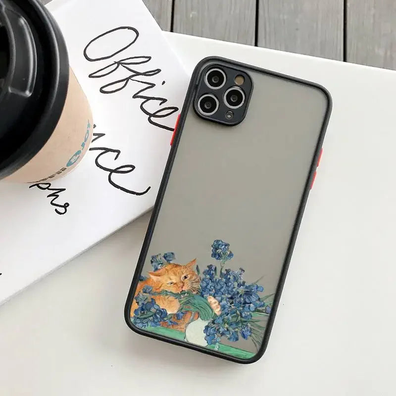 IPhone with a decorative case featuring a cat and blue flowers.