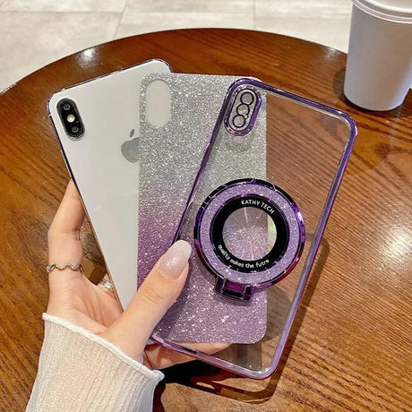 IPhone with glittery purple and silver gradient case featuring a camera-lens-shaped ring holder.