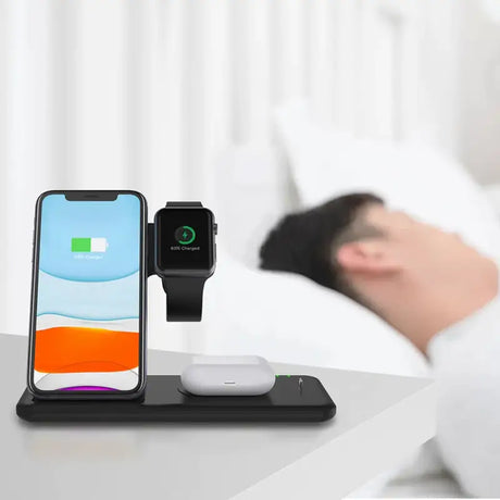 An iphone and a wireless charging station on a bed